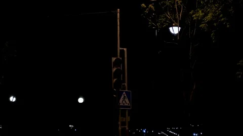 The traffic light flashes yellow at night next to the transition sign Stock Footage