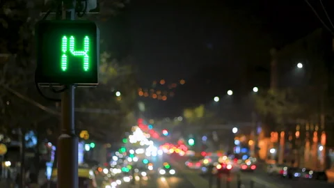 Traffic light with green countdown timer against the backdrop of a night city. Stock Footage 297611454