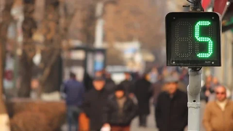Traffic Light with green seconds on a background of anonymous walking people Stock Footage 84969213
