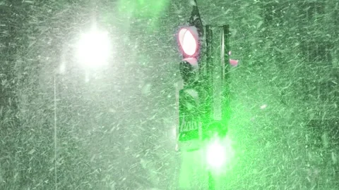 Traffic light illumination during heavy snowstorm at night, close up. Urban road Stock Footage 326749625