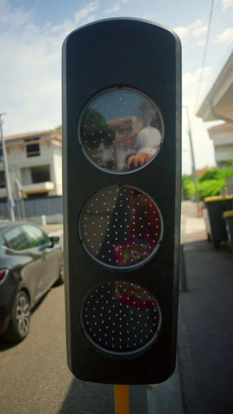 Traffic light with LED signal displaying a red stop symbol, reflecting a person Stock Footage 343221659
