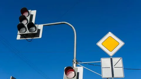 Traffic light with red light against the blue sky. Shallow depth of field. Stock Photos