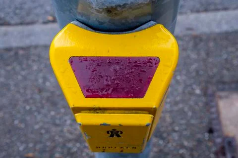Traffic light switch in yellow with raindrops at the street Stock Photos