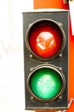 Traffic light with two lights, red and green, on a red pillar that indicates  Stock Photos