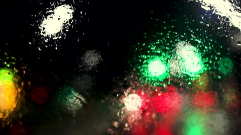 Traffic lights blurred by rain on a car windshield wet from rain Stock Footage 293128171