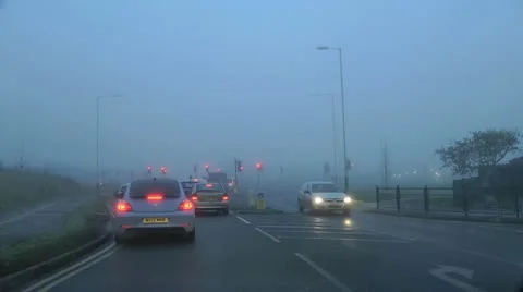 Traffic lights change at junction on ring road in fog 動画素材 15103283