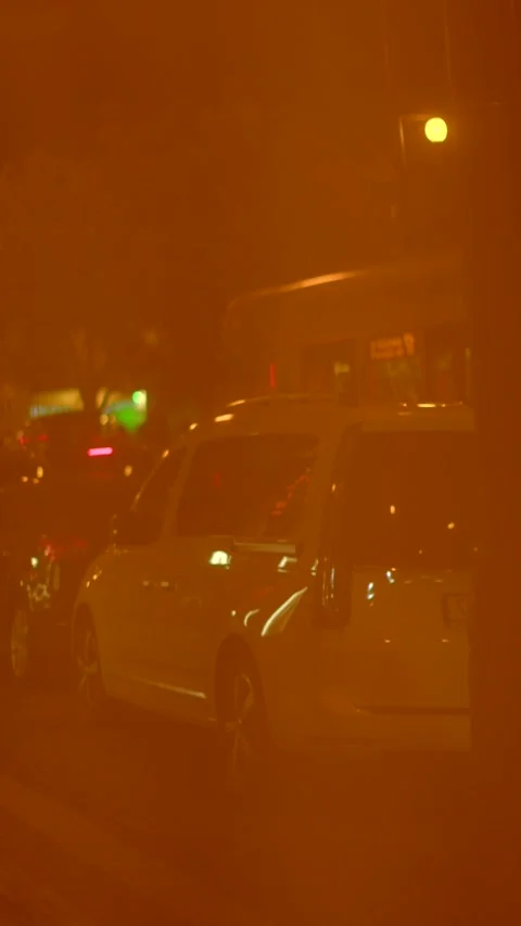 Traffic lights shimmer on damp roads under nighttime illumination Stock Footage 324592353