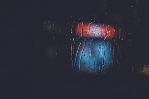 Traffic lights through the window in a rainy night Stock Photos