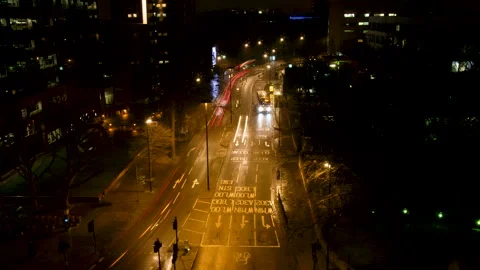 Traffic moves across an intersection in the City of London at night. Видео 135145726