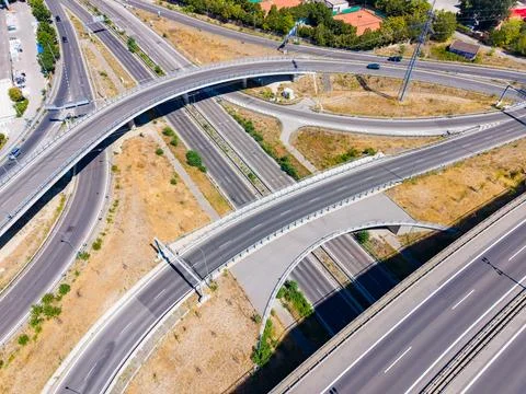 Traffic moves along the highway with multiple lanes and ramps. The scene show Stock Photos