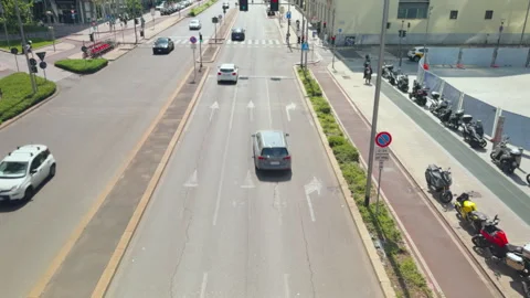 Traffic moving away from camera on Milan city street with bike lanes Stock Footage 338243437
