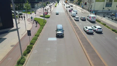 Traffic moving toward camera on Milan city street with bike lanes Stock Footage 338243448