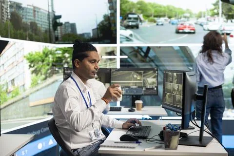 Traffic operator drinks coffee while seated at workstation desk Stock Photos