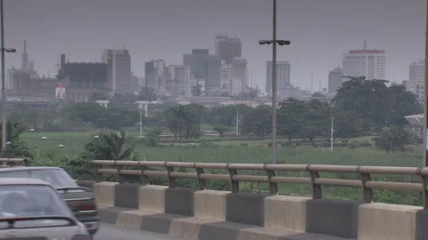 Traffic passes in foreground with view of Lagos skyline in background. Stock Footage 86760937
