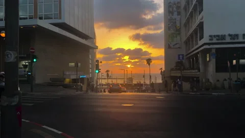 Traffic passes intersection leading to beach during dramatic  sunset in Tel-Aviv Stock Footage 165777560