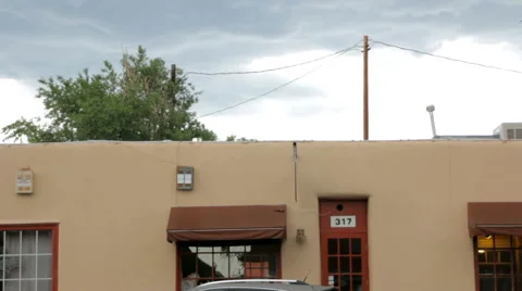 Traffic Passes by a Simple Adobe Building Stock Footage 64827872