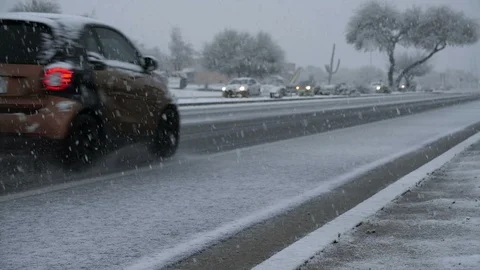 Traffic passing by during a rare snow storm in the southwest Stock Footage 103390106