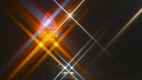 Traffic passing flashing keep level crossing clear warning sign at night uk Stock Footage 85598382