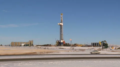 Traffic passing in front of a snowy fracking site Stock Footage 47940198