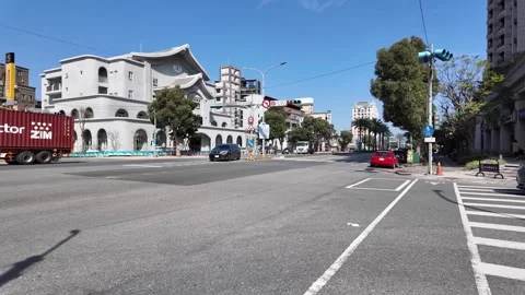 Traffic passing intersection with white building in Taipei Vídeos de archivo 345998609