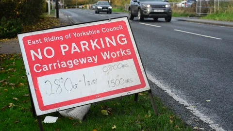 Traffic passing no parking warning sign of roadworks bubwith yorkshire uk Stock Footage 164525201