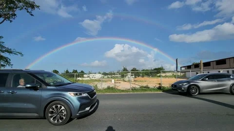 Traffic Passing By a Rainbow Formation in a Sunny Afternoon 4k Stock Footage 219592886