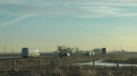 Traffic passing on a raised road through a Salt Marsh Stock Footage 1047332