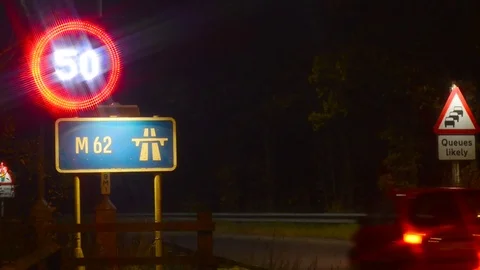 Traffic passing reduced speed 50mph limit warning sign on m62 uk Stock Footage 85051723