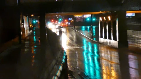 Traffic passing under viaduc during rain Stockbeeldmateriaal 125553360
