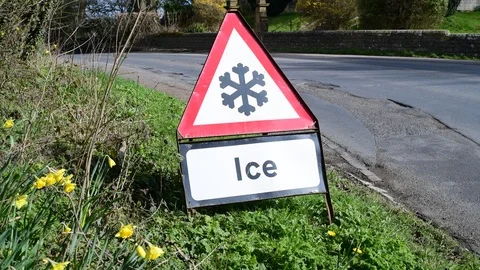 Traffic passing warning sign of ice on road ahead sproxton uk Stock Footage 127419059