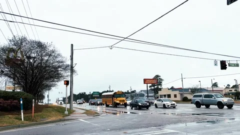 Traffic on a rainy day at an intersection with a passing Food Lion truck Stock Footage 147097250