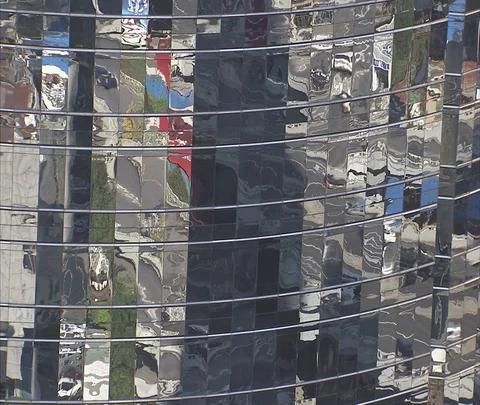 Traffic reflected and refracted in glass of high-rise building Video stock 86745074