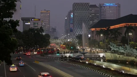 Traffic at roundabout with skyline in Jakarta Java Indonesia Video stock 82073718