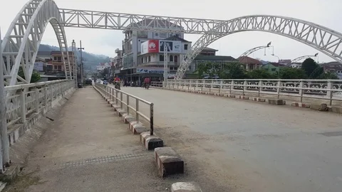 Traffic on Sam Neua central bridge, houses, ads, lanterns, metal structure, Laos Stockbeeldmateriaal 76799265
