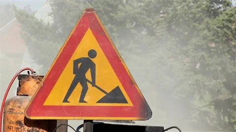 Traffic sign for road work. Dust rising into the air in the background. Smoke. Video stock 41490576