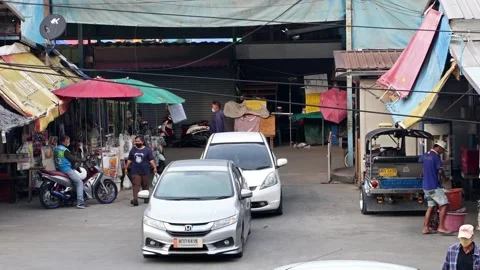 Traffic at a small intersection next to the market at dusk Stock Footage 255416670