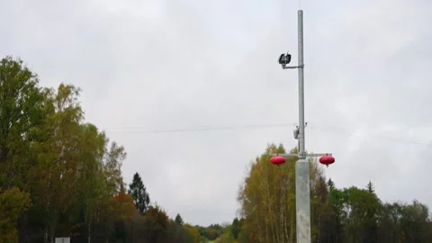 Traffic speed camera beside rural road under cloudy autumn sky Stock Footage 319018916