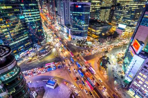 Traffic speeds through an intersection at night in Gangnam. Stock Photos