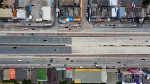 Traffic on a straight road that runs through a small town, Aerial view Vidéo 186552517
