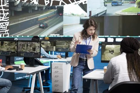 Traffic supervisor briefing seated operator at computer desk in control center Stock Photos