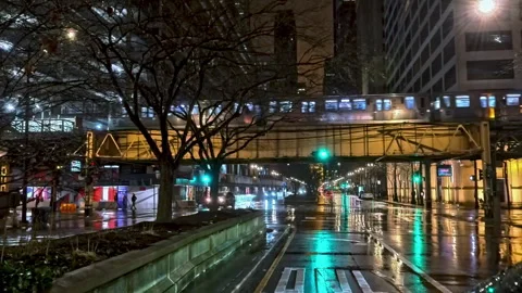 Traffic on wet streets and a elevated Train track in the Loop, night in Chicago Stock Footage 304046788