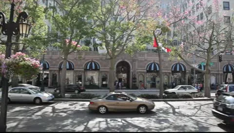 Traffic on Wilshire Blvd next to Beverly Wilshire Hotel in Los Angeles Stock Footage