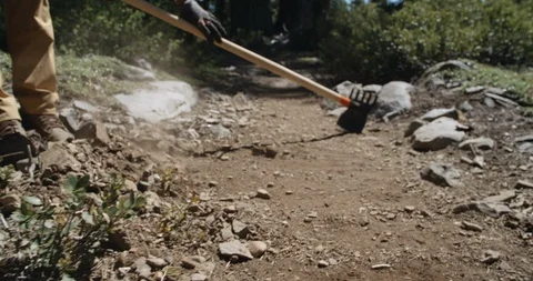 Trail maintenance crew using metal tool to clean path Stock-Footage 97665916