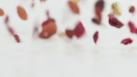 Trail mix tumbles in slow motion onto a white cyc Stock Footage 70672360