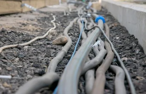 Trail of power electrical cables on the ground Stock Photos