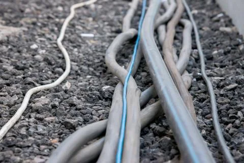Trail of power electrical cables on the ground Stock Photos