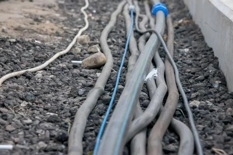 Trail of power electrical cables on the ground Stock Photos