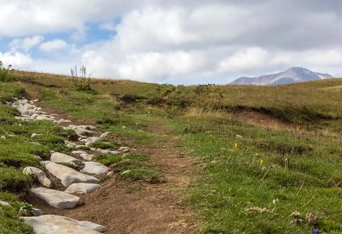 A trail on a rocky mountain plateau located on the path of a tourist route wi Stock Photos