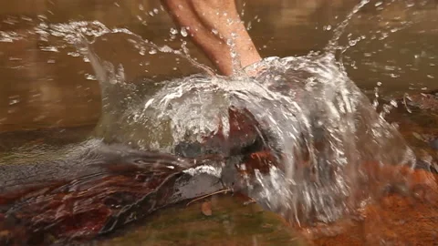 Trail runner breaks water in a flowing stream. Stock-Footage 136095456