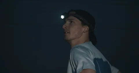Trail runner with head lamp jogging at night Stock Footage 98432087